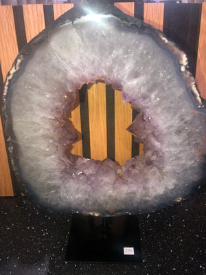 amethyst crystal portal mounted on a black metal stand.