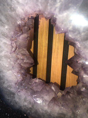 amethyst crystal portal mounted on a black metal stand.