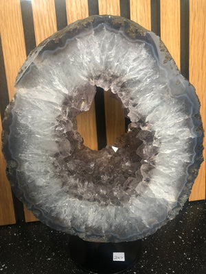 amethyst crystal portal mounted on a black metal stand.