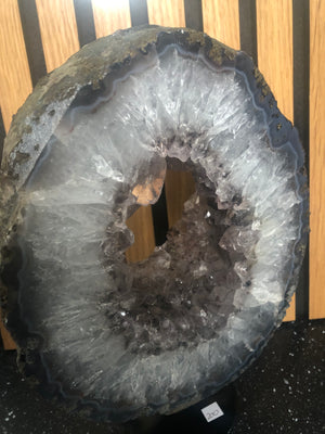 amethyst crystal portal mounted on a black metal stand.