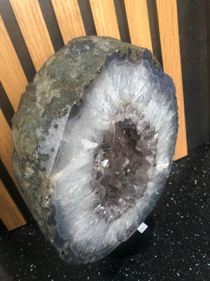 amethyst crystal portal mounted on a black metal stand.