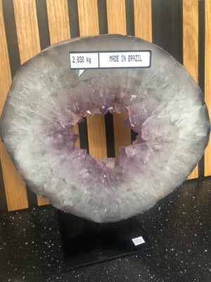 amethyst crystal portal mounted on a black metal stand.