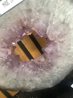 amethyst crystal portal mounted on a black metal stand.