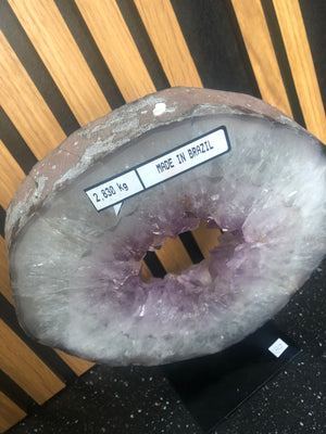 amethyst crystal portal mounted on a black metal stand.